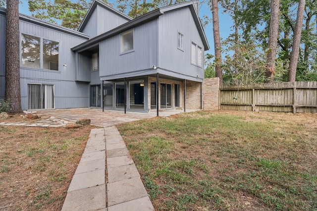 rear view of house with a yard and a patio