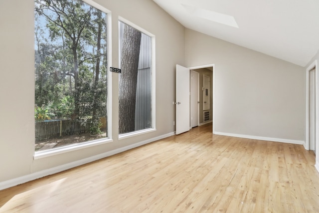 unfurnished room with light hardwood / wood-style flooring and lofted ceiling with skylight