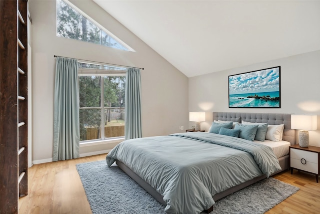 bedroom featuring wood-type flooring and high vaulted ceiling