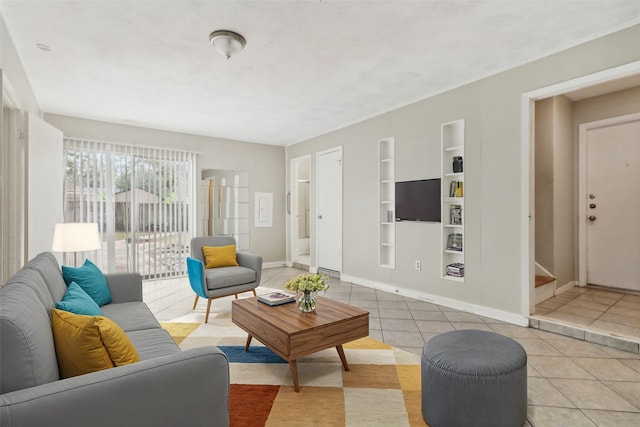 living room with built in shelves and light tile patterned floors