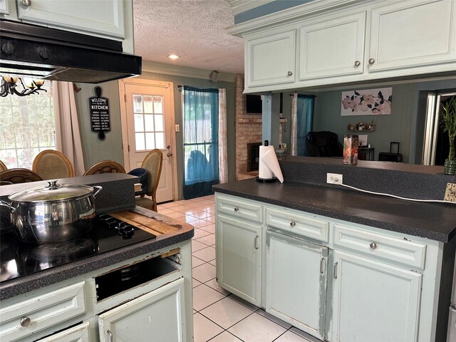 12419 Longbrook Dr, Houston, TX 77099 - kitchen featuring dark countertops, black electric stovetop, white cabinetry, a textured ceiling, and light tile patterned floors