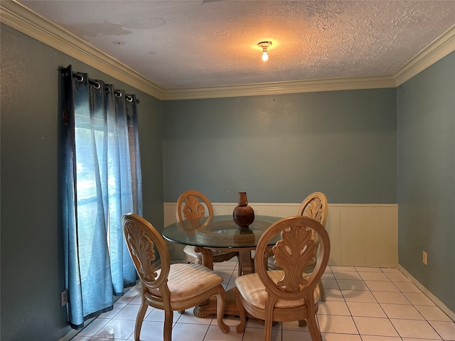 dining room with a textured ceiling, light tile patterned floors, and crown molding