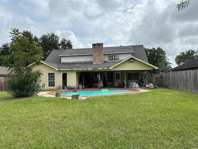 12419 Longbrook Dr, Houston, TX 77099 - back of house with a chimney, a patio area, a fenced in pool, a fenced backyard, and a yard