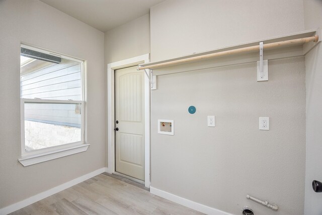 clothes washing area with baseboards, gas dryer hookup, washer hookup, laundry area, and light wood-style floors