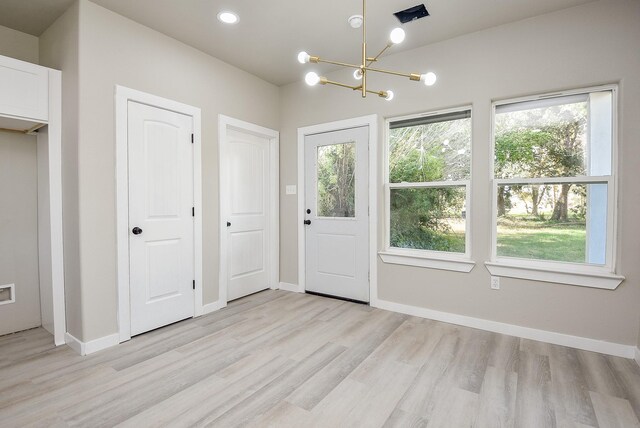 doorway to outside with light wood-style flooring, baseboards, and a wealth of natural light