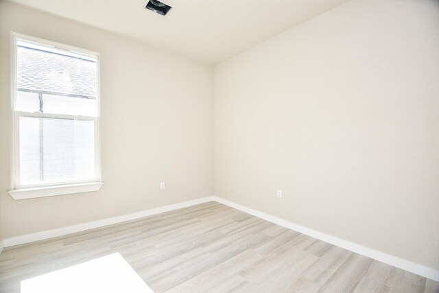 spare room featuring light wood-type flooring and baseboards