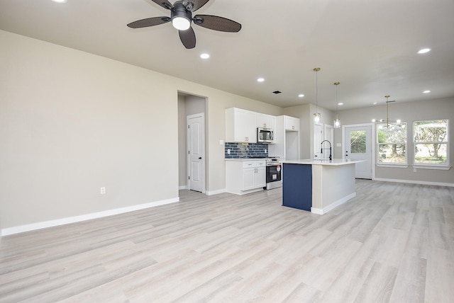 100 S 12 Th St, West Columbia, TX 77486 - kitchen featuring tasteful backsplash, light wood finished floors, stainless steel appliances, white cabinetry, and a ceiling fan