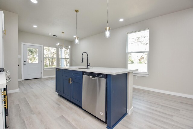 kitchen featuring light wood-type flooring, light countertops, appliances with stainless steel finishes, blue cabinets, and a sink