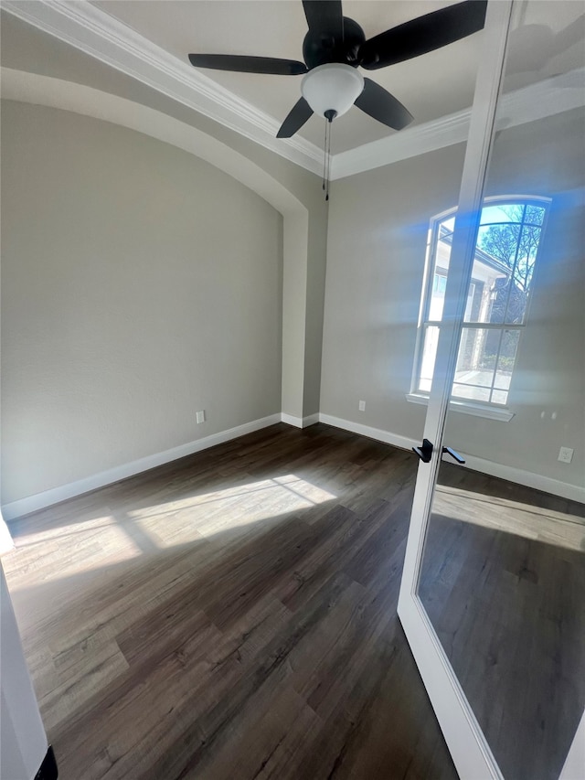 empty room with ceiling fan, ornamental molding, and dark hardwood / wood-style flooring