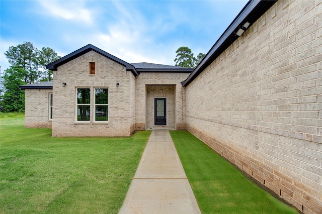 doorway to property with a lawn