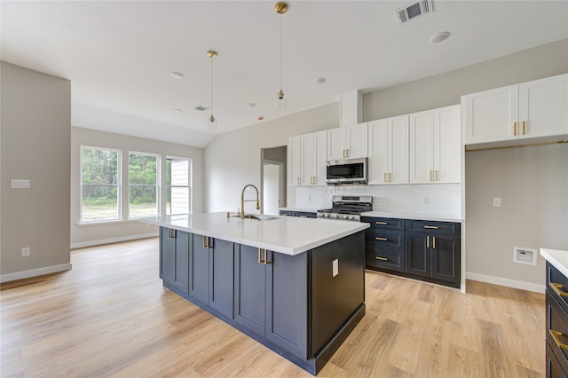 kitchen with pendant lighting, white cabinets, sink, a kitchen island with sink, and appliances with stainless steel finishes