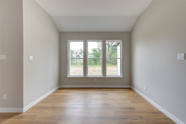 empty room featuring lofted ceiling and light hardwood / wood-style floors