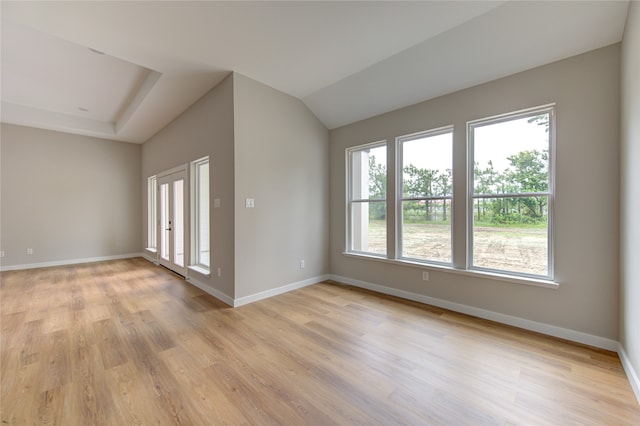 unfurnished room featuring light hardwood / wood-style flooring and lofted ceiling