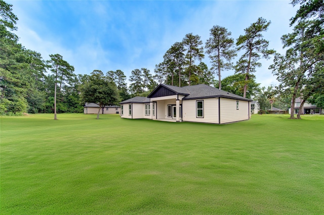 rear view of property with a yard