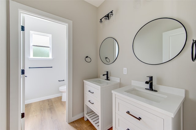 bathroom featuring vanity, toilet, and hardwood / wood-style flooring