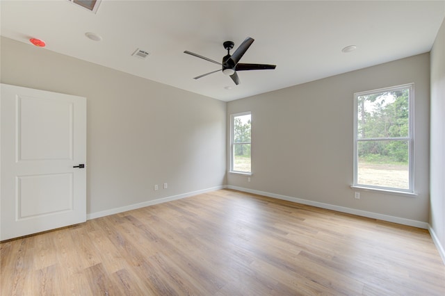 spare room with ceiling fan, light hardwood / wood-style floors, and a wealth of natural light