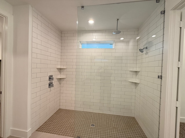 bathroom with tile patterned flooring and a tile shower