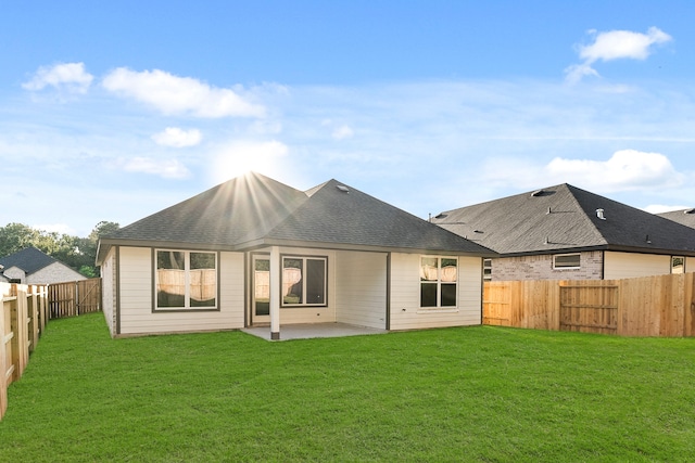 rear view of house with a yard and a patio