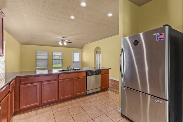 kitchen featuring stainless steel appliances, lofted ceiling, kitchen peninsula, sink, and ceiling fan