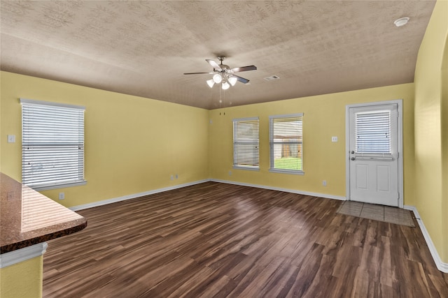 unfurnished living room featuring a textured ceiling, dark hardwood / wood-style floors, and ceiling fan