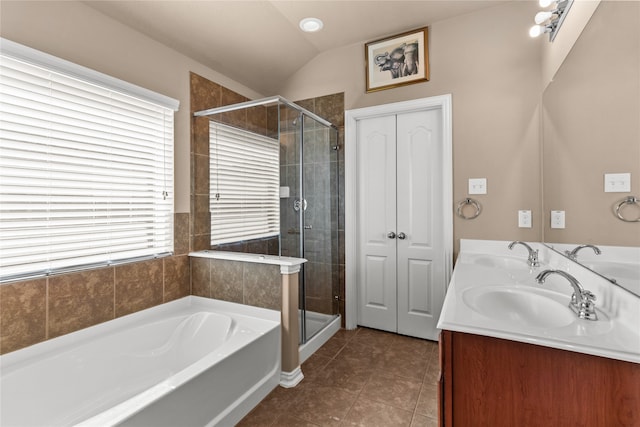 bathroom featuring vanity, vaulted ceiling, tile patterned flooring, and separate shower and tub