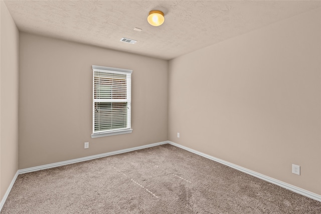 carpeted spare room featuring a textured ceiling