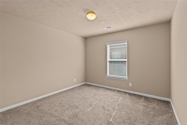 unfurnished room with a textured ceiling and carpet floors