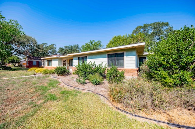 single story home featuring a front lawn