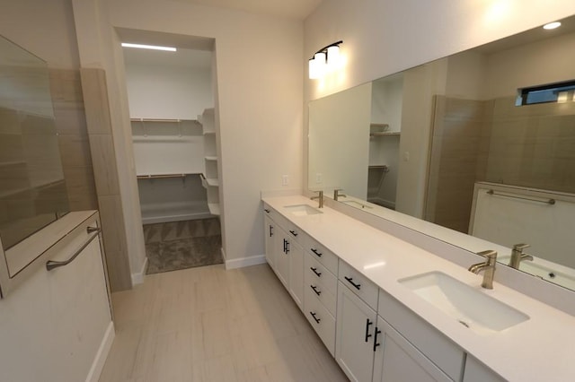 bathroom with vanity and a tile shower