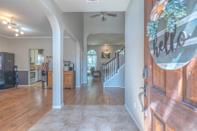 foyer entrance with ceiling fan, light hardwood / wood-style flooring, and ornamental molding