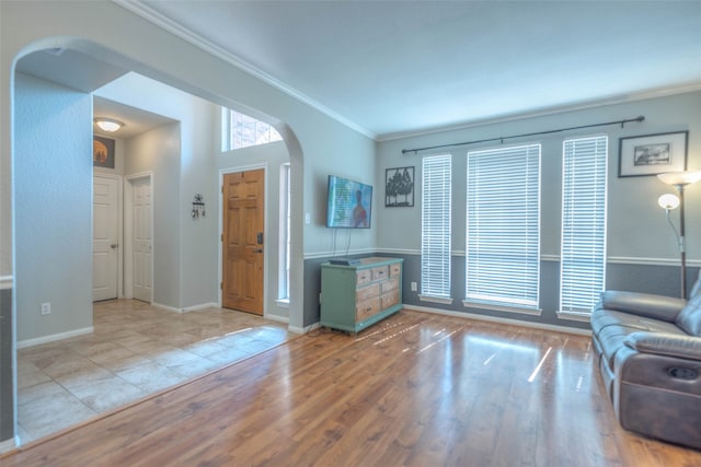 unfurnished living room with light hardwood / wood-style flooring and ornamental molding