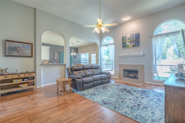 living room with hardwood / wood-style floors, ceiling fan, and a tile fireplace