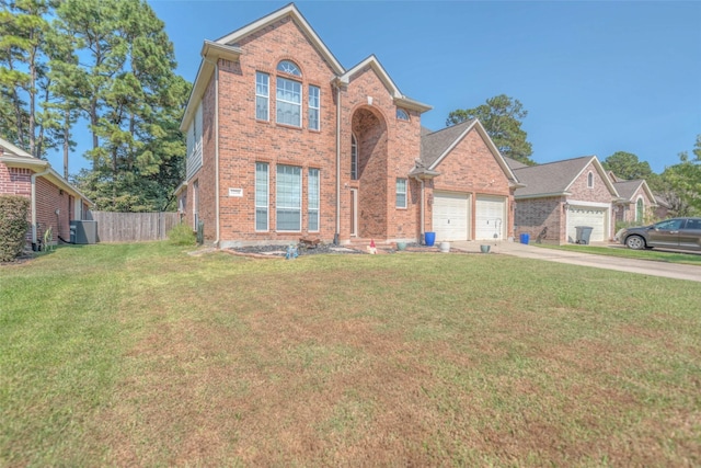 front facade featuring a front yard, a garage, and central AC unit