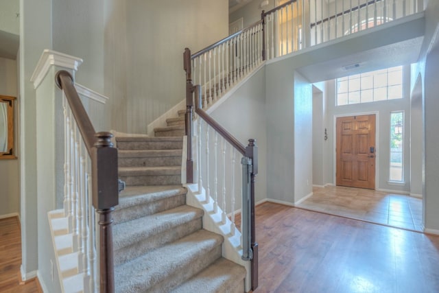 foyer featuring hardwood / wood-style flooring and a towering ceiling