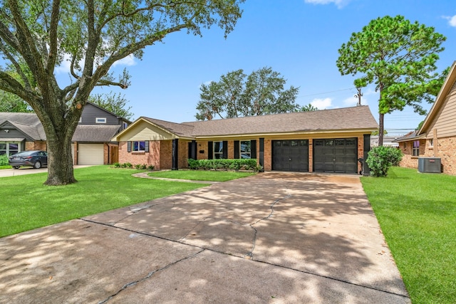 ranch-style home featuring a garage, a front yard, and central AC unit