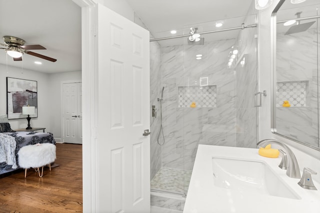 bathroom with walk in shower, hardwood / wood-style floors, vanity, and ceiling fan