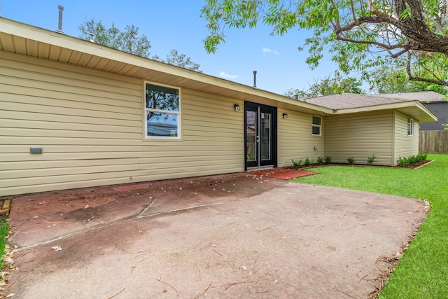 back of house with a patio area and a lawn