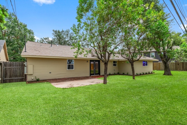 rear view of house featuring a lawn and a patio area