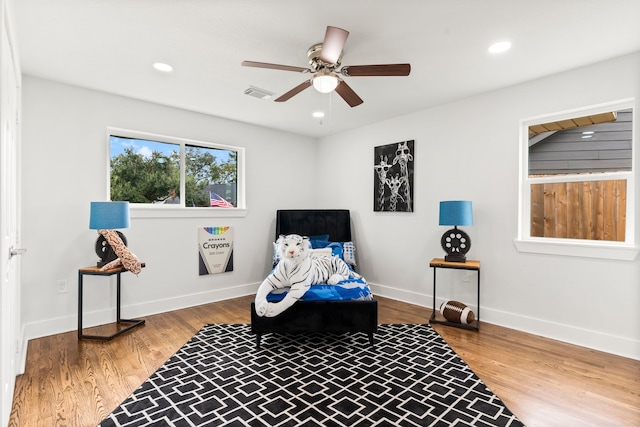 living area featuring wood-type flooring and ceiling fan