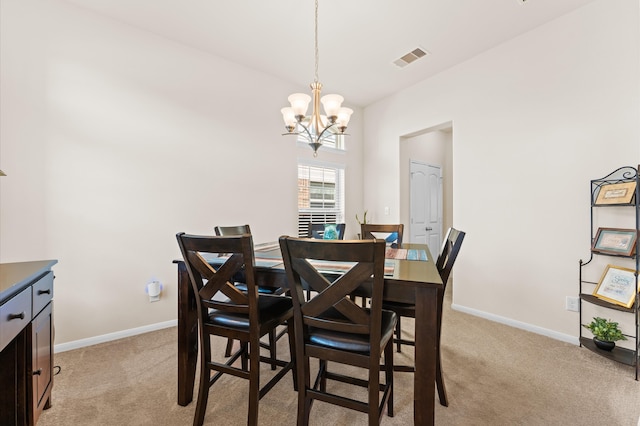 carpeted dining space featuring an inviting chandelier