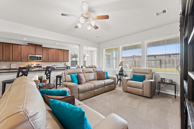 living room featuring light colored carpet and ceiling fan