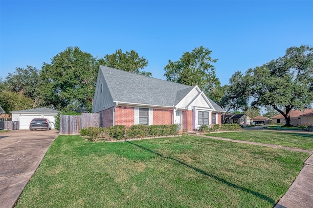 view of front of house with a front yard, a garage, and an outbuilding