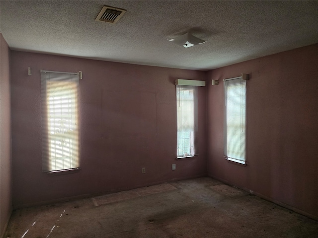 unfurnished room with a textured ceiling