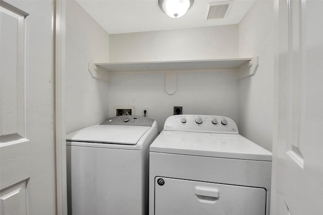 clothes washing area with separate washer and dryer