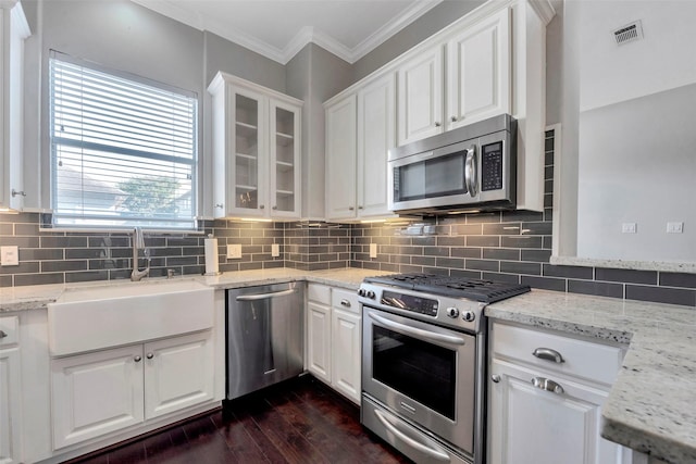 kitchen featuring dark hardwood / wood-style flooring, white cabinetry, stainless steel appliances, and tasteful backsplash