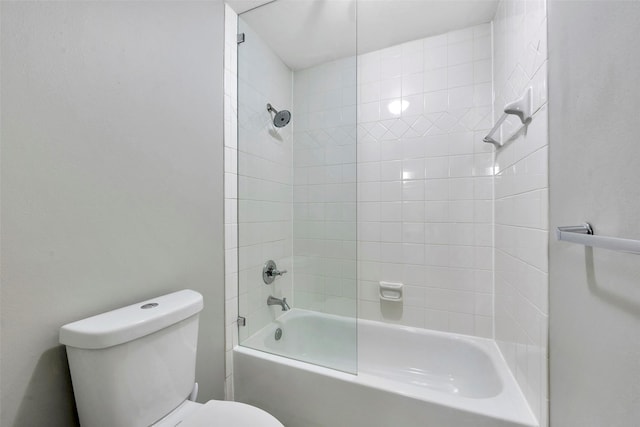 bathroom with tiled shower / bath combo and toilet