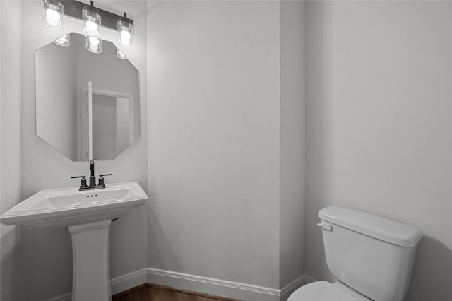 bathroom with toilet, hardwood / wood-style floors, and sink