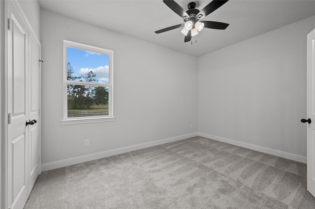 empty room with ceiling fan and light colored carpet