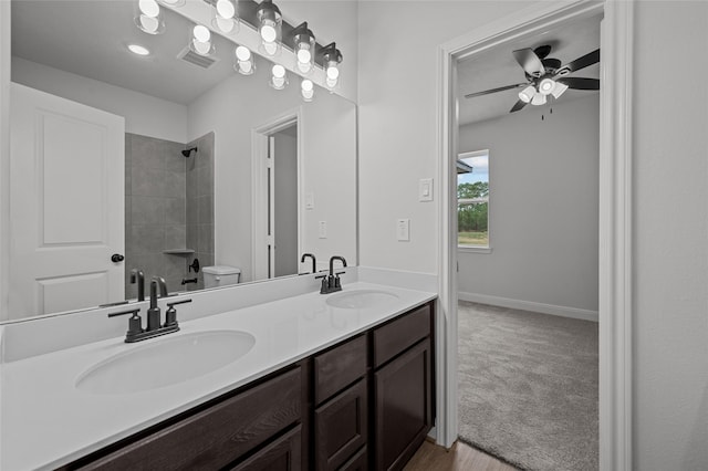 bathroom featuring toilet, vanity, and ceiling fan