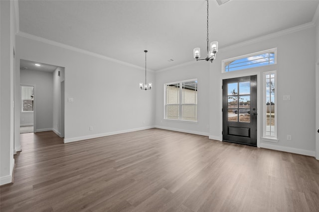 interior space featuring an inviting chandelier, ornamental molding, and hardwood / wood-style flooring